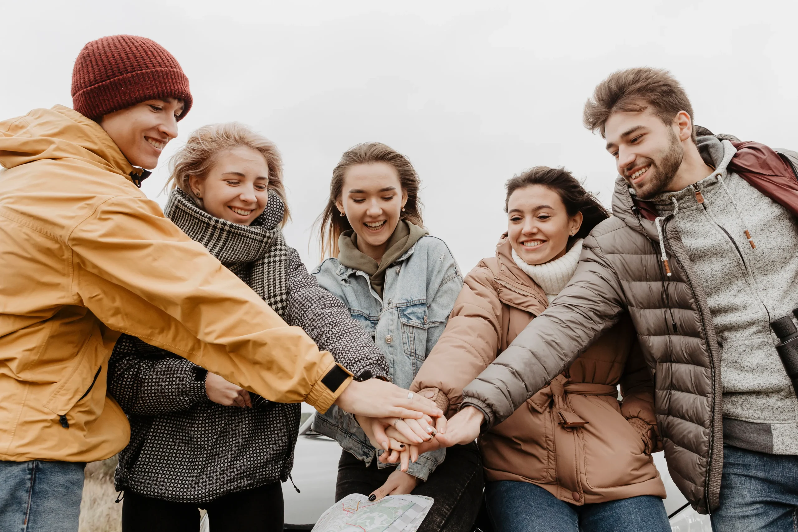 happy-friends-putting-hands-together